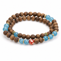 Double wrap agarwood bracelet with blue accent beads on white background