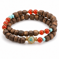 Double wrap agarwood bracelet with turquoise and red accent beads on white background