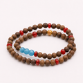 Single continuous double-wrap agarwood bracelet with blue and red accent beads on white background